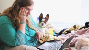 Frustrated Business Owner With Dog Working On Website On Laptop In Bed