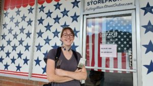 Local Mural and Window Painter Carol McElroy Finishes Virtual Storefronts Pilot Window Display in August 2022